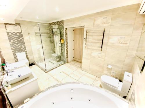 a bathroom with a tub and a shower and a toilet at C&C HOTEL VIBES Randpark Ridge JHB 14 Units Available in Boskruin