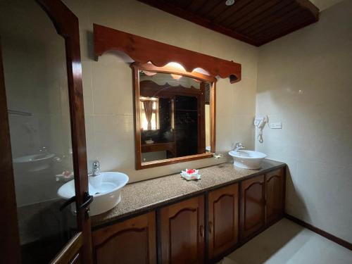 a bathroom with two sinks and a large mirror at Villa Chez Batista in Takamaka