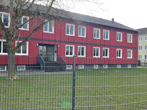 a red building with a fence in front of it at Yebs Hotel in Günzburg