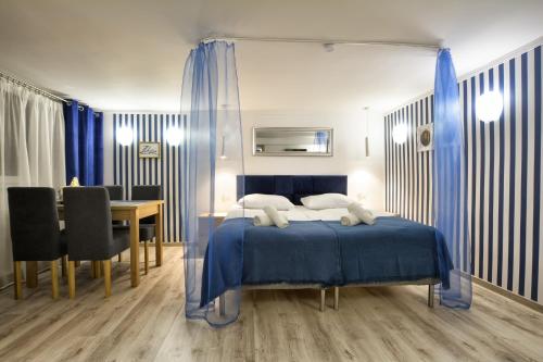 1 dormitorio con 1 cama azul, mesa y sillas en Apartament Niebieski, en Oleśnica