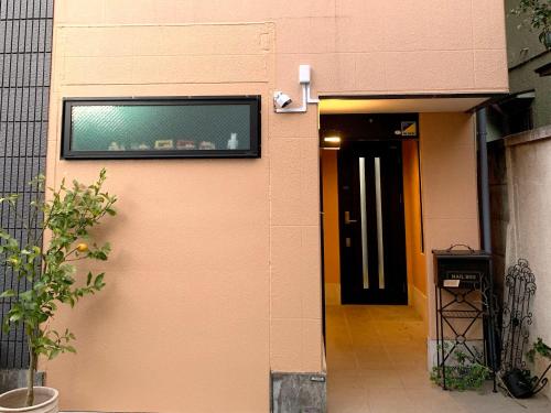 a television on the side of a building with a door at 4 bedrooms cozy house, 5 min JR train to Shinjuku, GRADIA Koenji in Tokyo