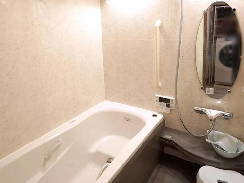 a bathroom with a tub and a toilet and a phone at 4 bedrooms cozy house, 5 min JR train to Shinjuku, GRADIA Koenji in Tokyo