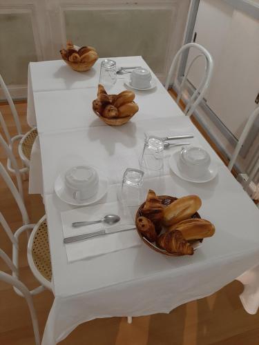una mesa blanca con un tazón de comida. en Hôtel Les Beaux Arts- Limoges Hypercentre en Limoges