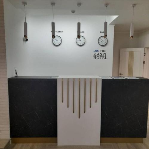 a room with clocks on the wall and a counter at Kaspi Hotel in Uralsk