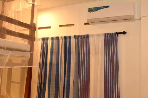a bathroom with a shower curtain and a heater at Villa Polhena in Matara