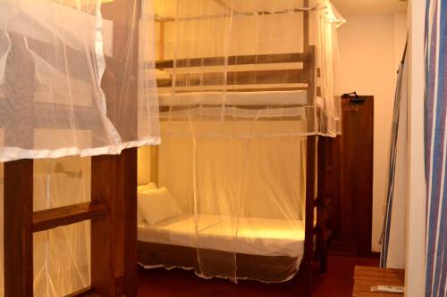 a bedroom with a bunk bed with a curtain at Villa Polhena in Matara