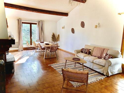 a living room with a couch and a table at Villa dans un cadre verdoyant , piscine et jardin in Porto-Vecchio