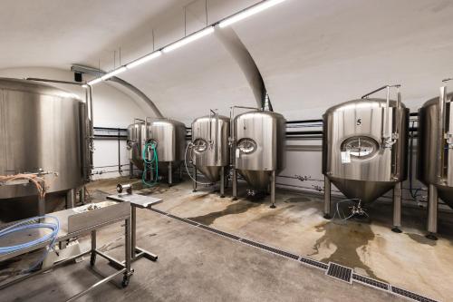 a row of silver tanks in a brewery at Pivovar Tupadly in Tupadly