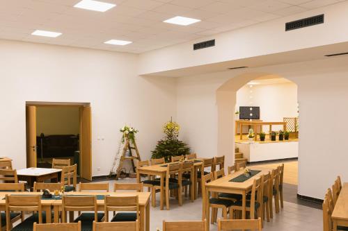 a restaurant with wooden tables and chairs and a kitchen at Pivovar Tupadly in Tupadly