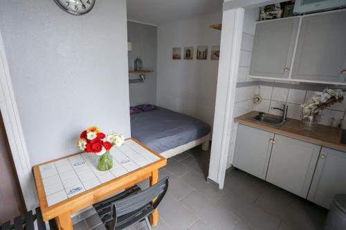 - une petite cuisine avec une table et un vase de fleurs dans l'établissement appartement 4 pers vue mer, à Hyères