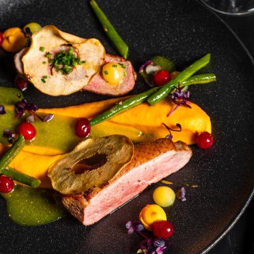 a plate of food with a piece of meat and vegetables at Loop Hotel Vilnius in Vilnius