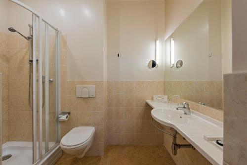 a bathroom with a toilet and a sink and a shower at Congress Hotel in Vilnius