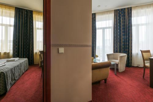 a hotel room with a bed and a table and chairs at Congress Hotel in Vilnius
