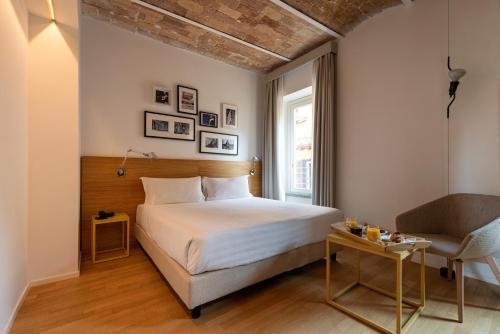 ローマにあるCoronari Palaceのベッドルーム1室(ベッド1台、椅子、窓付)