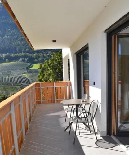 a patio with a table and chairs on a balcony at Sunnig Apartment Sonnenschein in Vollan