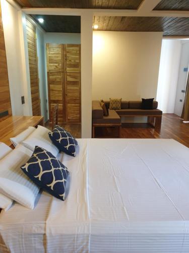 a bedroom with a large white bed with blue pillows at Giri Villa in Tangalle