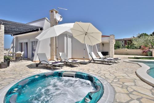 a pool with chairs and umbrellas on a patio at Casa Siesta in Murine
