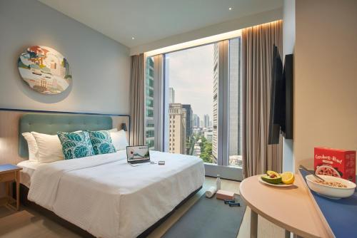 a hotel room with a bed and a large window at Citadines Raffles Place Singapore in Singapore