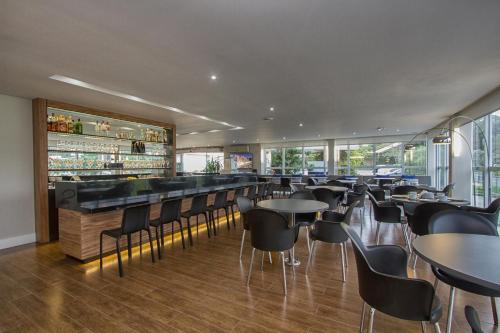 a bar with tables and chairs in a restaurant at Le CanarD Joinville in Joinville