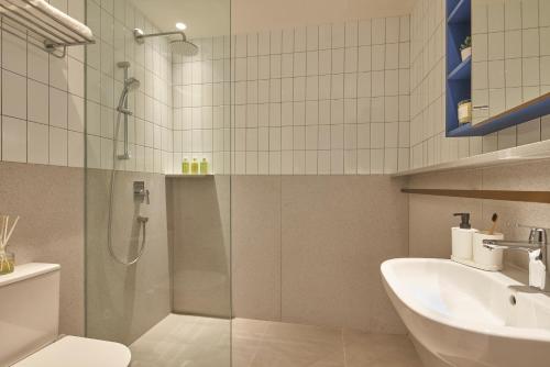 a bathroom with a shower and a toilet and a sink at Citadines Raffles Place Singapore in Singapore