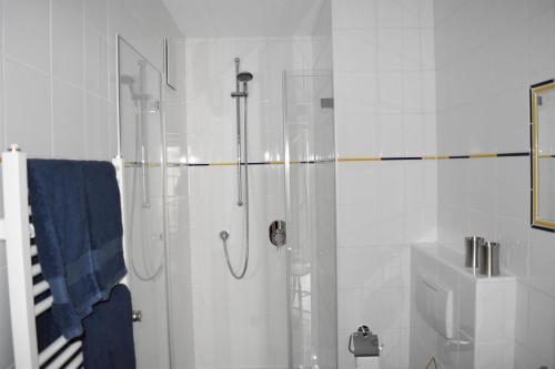 een witte badkamer met een douche en een wastafel bij Ferienwohnung Drei Seen in Blaichach