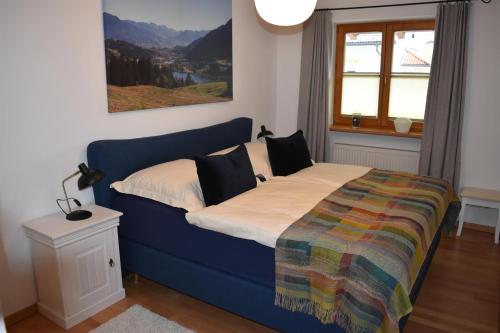 een slaapkamer met een blauw bed en een kleurrijke deken bij Ferienwohnung Drei Seen in Blaichach