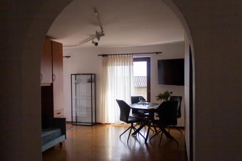 Panoramic Orselina في Orselina: غرفة معيشة مع طاولة طعام وكراسي