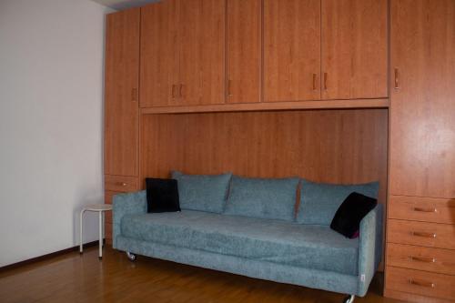 Panoramic Orselina في Orselina: أريكة زرقاء في غرفة مع دواليب خشبية