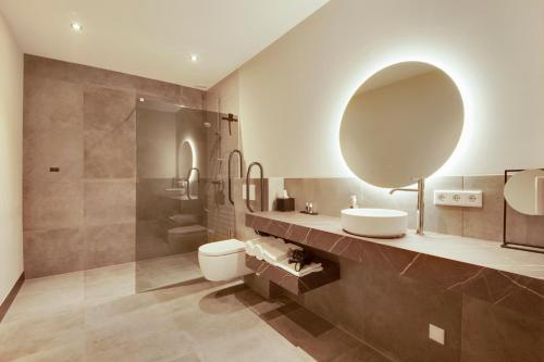a bathroom with a toilet and a sink and a mirror at Op dn Kreijtenberg in Milheeze