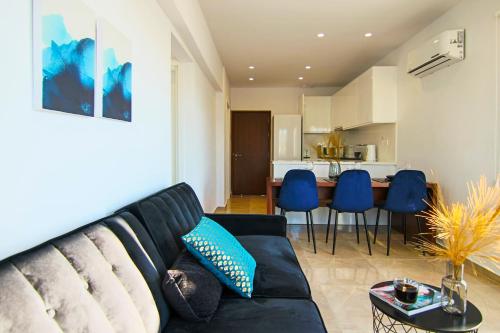 a living room with a black couch and a kitchen at Phaedrus Living : Seaside Luxury Flat Lighthouse 70 in Paphos