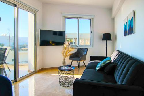 uma sala de estar com um sofá e uma televisão em Phaedrus Living : Seaside Luxury Flat Lighthouse 70 em Paphos