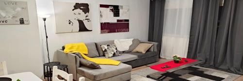 a living room with a couch and a table at Magnifique Appartement Lille WIFI Parking by Servallgroup in Mons-en-Baroeul