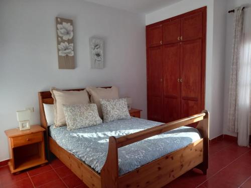 um quarto com uma cama e um armário de madeira em Casa Ramos em Arrecife