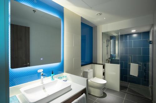 uma casa de banho com um lavatório, um WC e um espelho. em Holiday Inn Express Shantou City Center, an IHG Hotel em Shantou