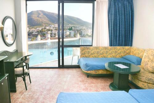 a living room with a couch and a large window at KAKTUS Hotel Kaktus Albir in Albir