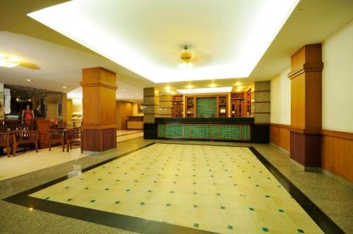 a large room with a tile floor with a swimming pool at Rambuttri Village Plaza in Bangkok