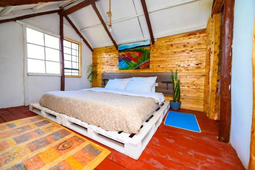 a bedroom with a bed in a room with wooden walls at Olrok Farm House in Nyahururu