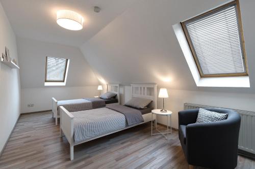 a bedroom with two beds and a couch and a window at Arkadia-Home-Hamburg-Airport-Apartment in Hamburg