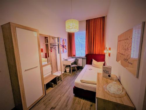 a hotel room with a bed and a desk and a room at Arena Hotel in Gelsenkirchen