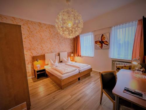 a bedroom with a bed and a chandelier at Arena Hotel in Gelsenkirchen