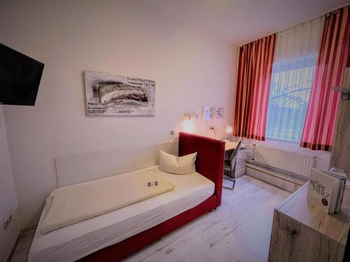 a bedroom with a bed with a red frame at Arena Hotel in Gelsenkirchen
