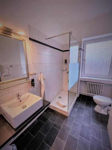 a bathroom with a sink and a shower and a toilet at Arena Hotel in Gelsenkirchen
