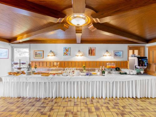 a large white table in a room with a ceiling at Landhotel Gabriele in Unterwössen