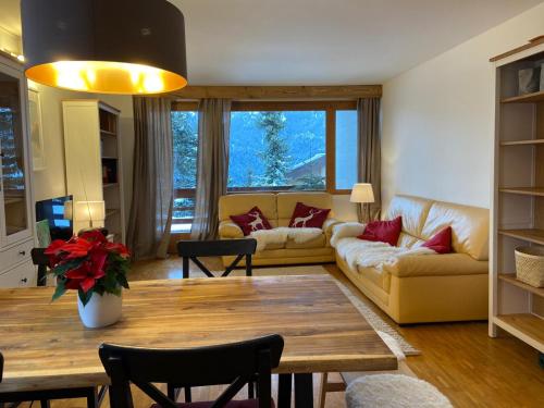 ein Wohnzimmer mit einem Sofa und einem Tisch in der Unterkunft Rose des Alpes in Leysin
