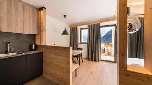 a kitchen and dining room with a view of a mountain at Im Wiesengrund Apartments in Sesto