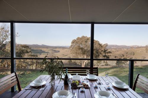 a wooden table with a view of a field at Turon Gates - Mountain Retreat in Capertee
