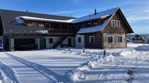 a house in the snow with a lot of snow at Apartmány U Fibichů in Orlické Záhoří 