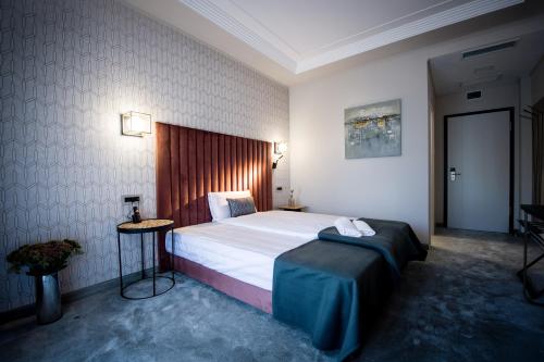 a hotel room with a large bed and a table at Nora Prestige in Timişoara