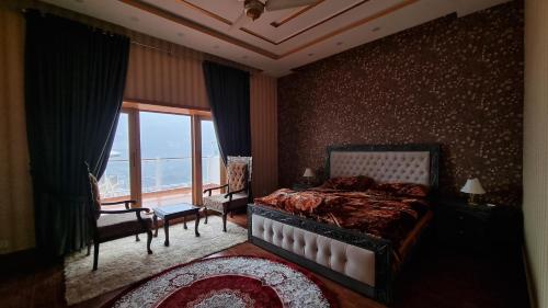 a bedroom with a bed and a large window at The Swat House in Swat