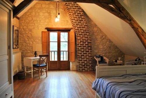 a bedroom with an attic with a bed and a desk at Le Tulipier de Virginie in Noyers-sur-Cher